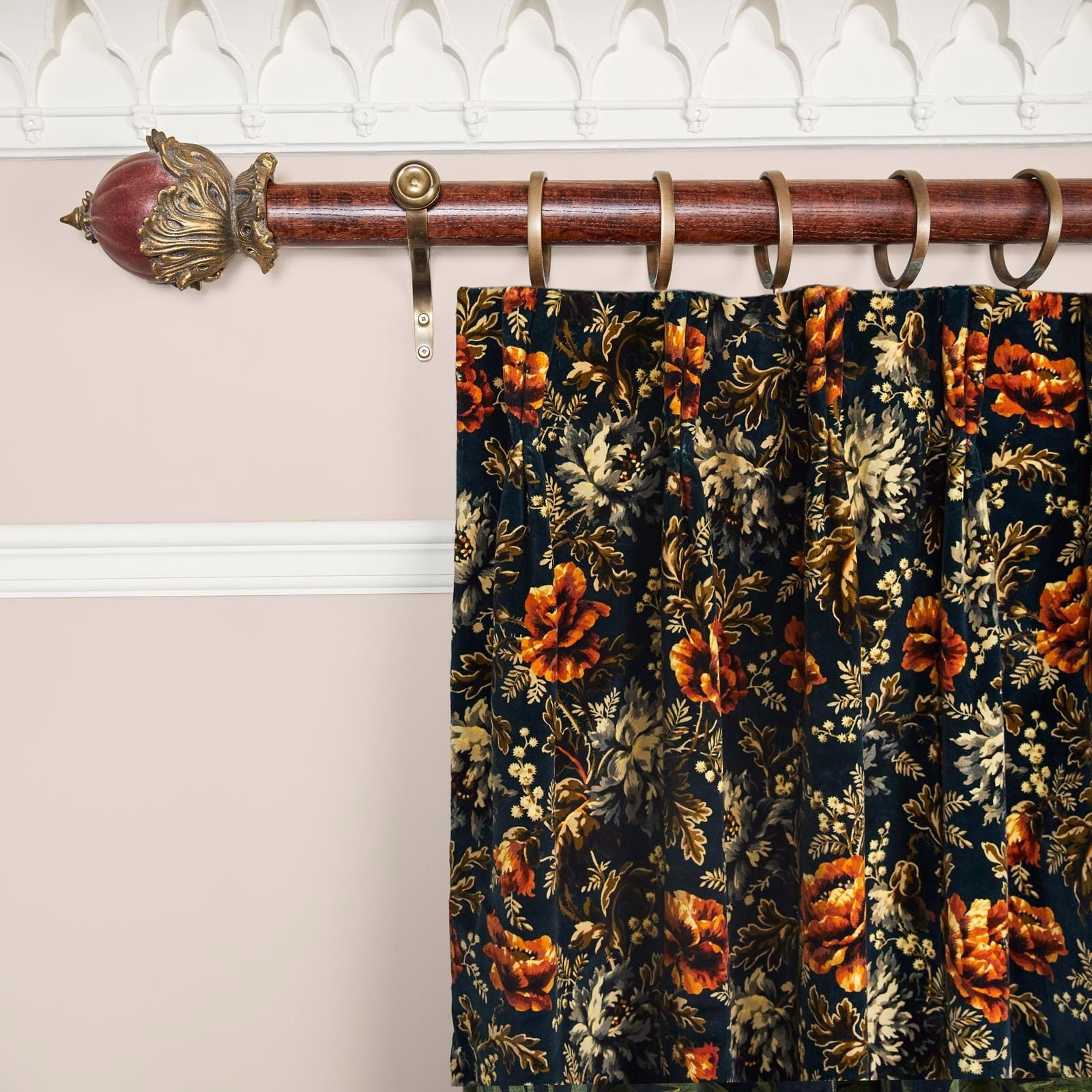 Midnight velvet curtain with orange flowers and muted gold foliage in deep pleats