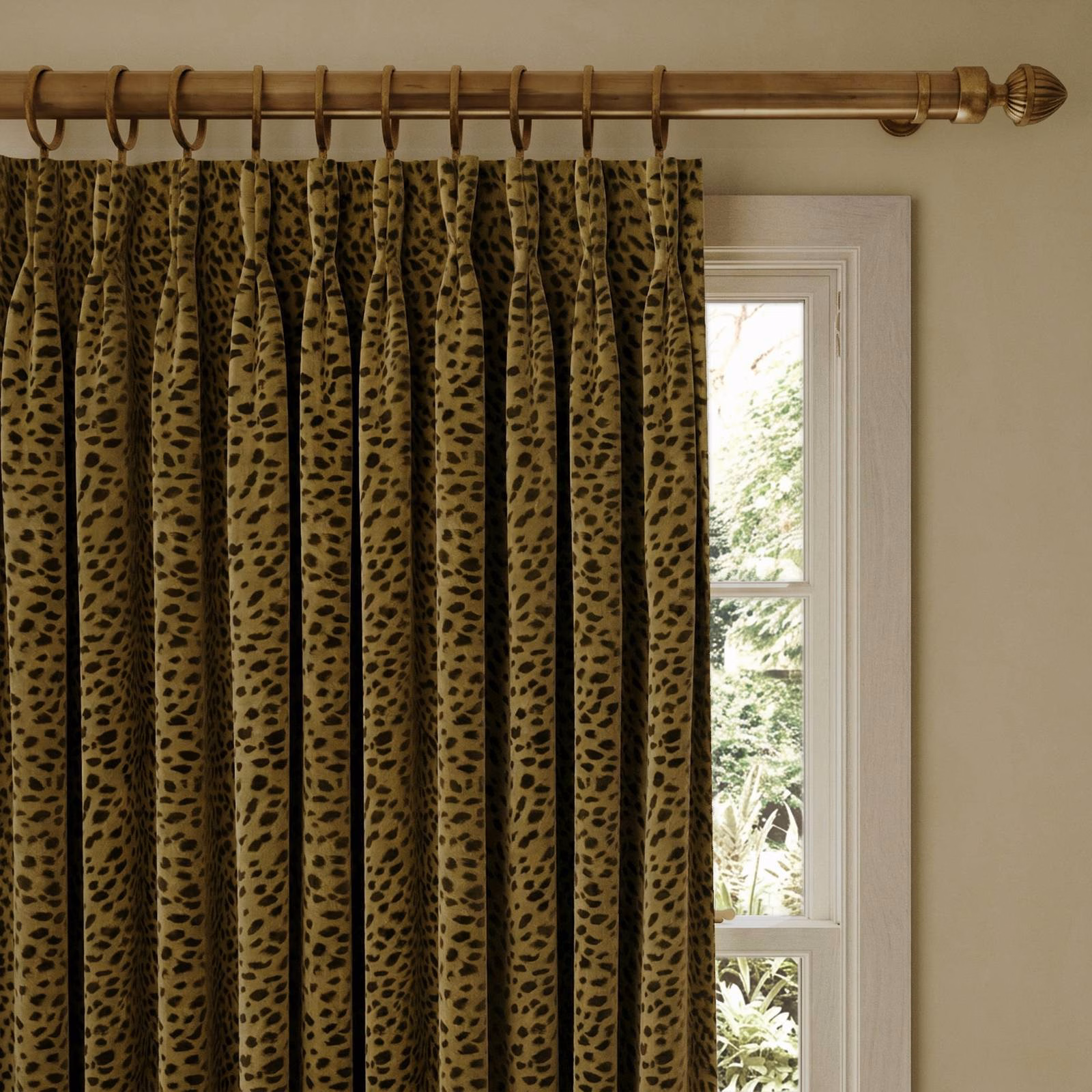 Olive-gold velvet curtain with irregular black animal spots in deep gathered folds