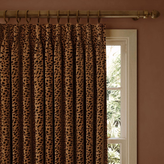 Russet-brown velvet curtain with black leopard-style spots in deep pleats
