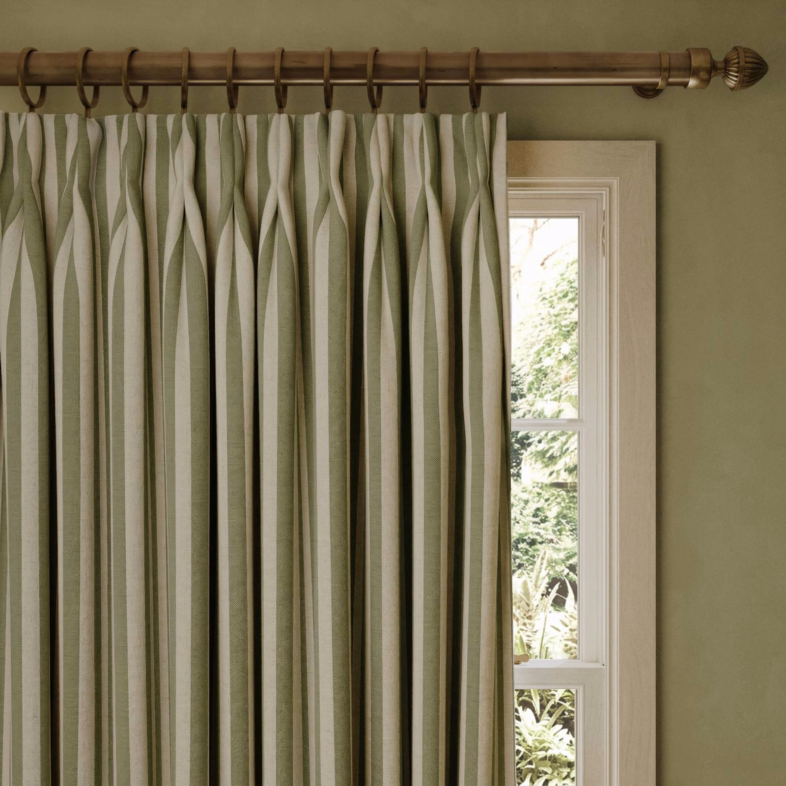 Muted verdigris and ivory undulating stripe jacquard curtains beside a bright window