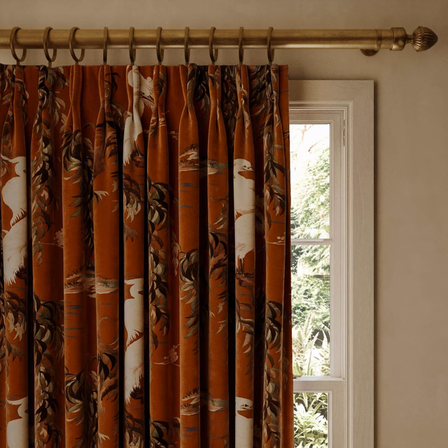 Tobacco velvet curtain with dark botanical foliage and cream floral accents in deep folds