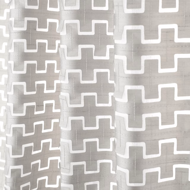 Cool steel-grey textile with white angular meander lines and softly translucent weave