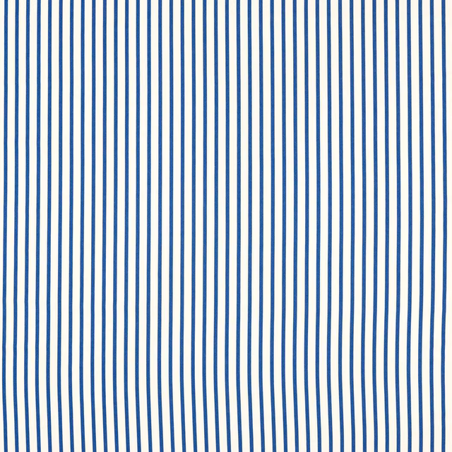 Cool lapis-blue ribbons ripple across an ivory ground in this close swatch
