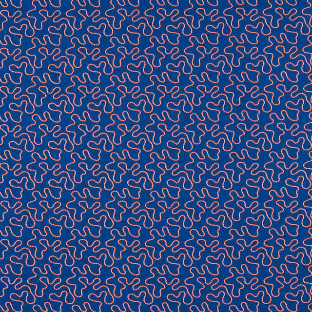 Deep lapis blue fabric with dense pink-coral squiggle motifs and fine woven texture