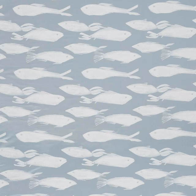 White fish swimming across a soft blue-grey Kaku Celestial fabric