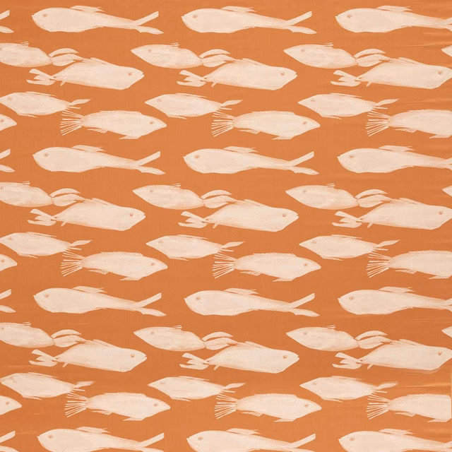 Warm paprika fabric with repeated cream fish motifs and subtle surface texture