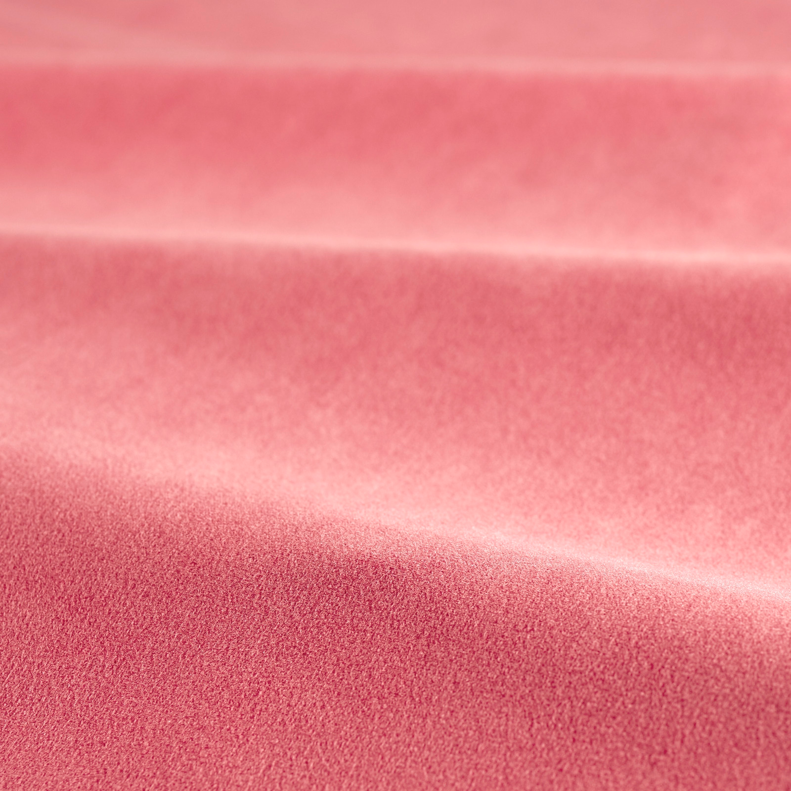 Rosy coral pink velvet showing smooth pile and shifting highlights across folded swatch