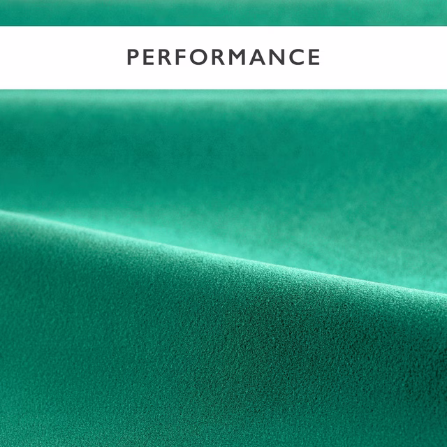 Close-up of emerald green velvet with a plush pile and luminous folded highlight