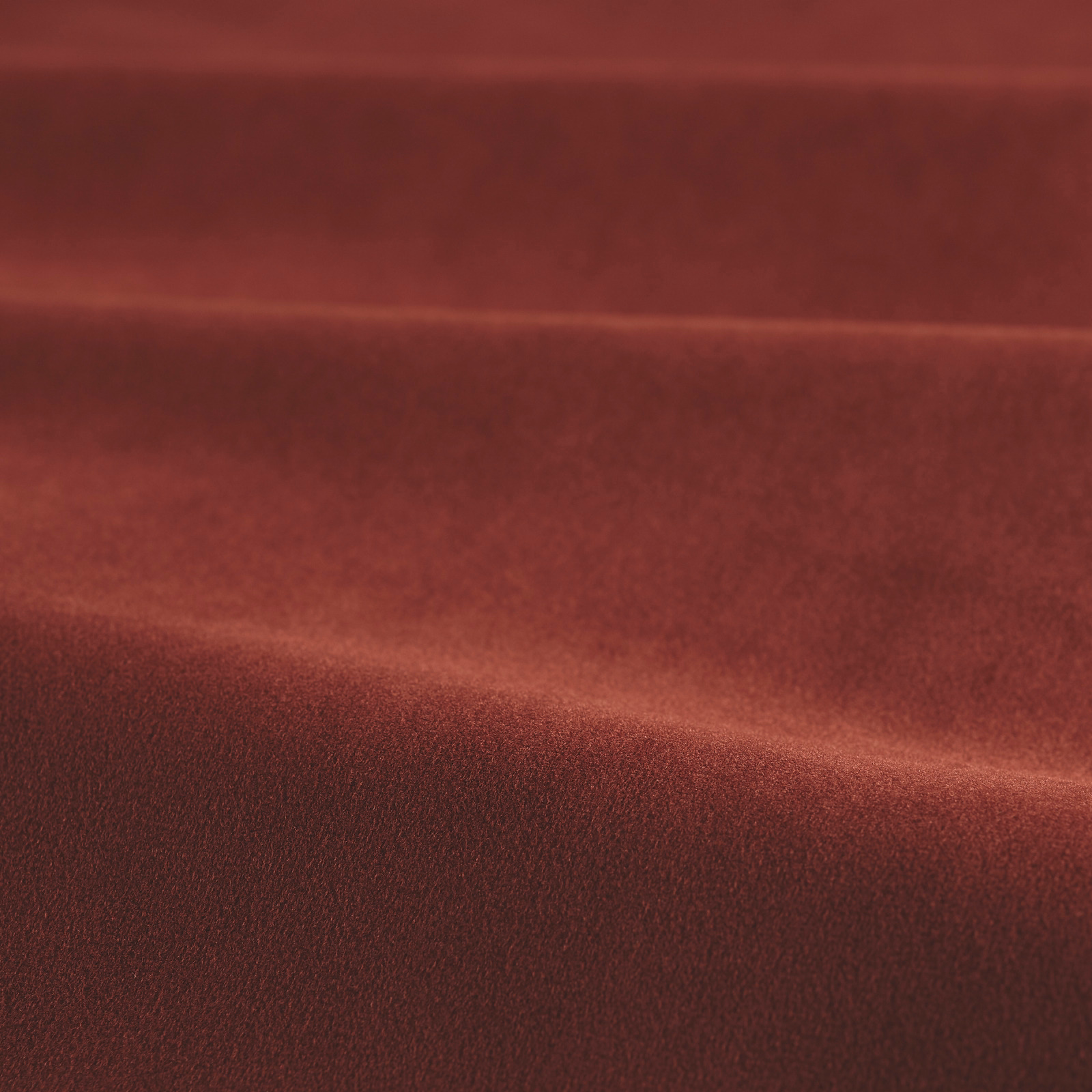 Deep harissa-red velvet with a soft nap and highlighted sheen across folded fabric