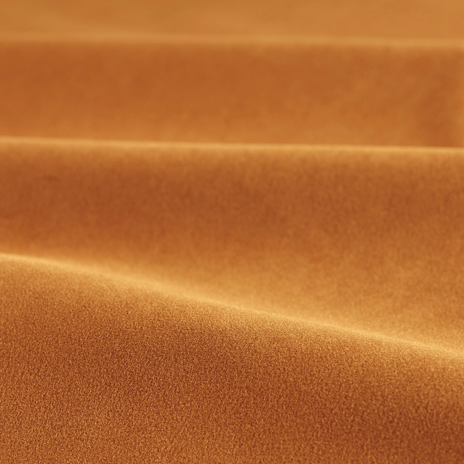 Warm paprika-orange velvet with soft copper highlights folding across a dense plain pile