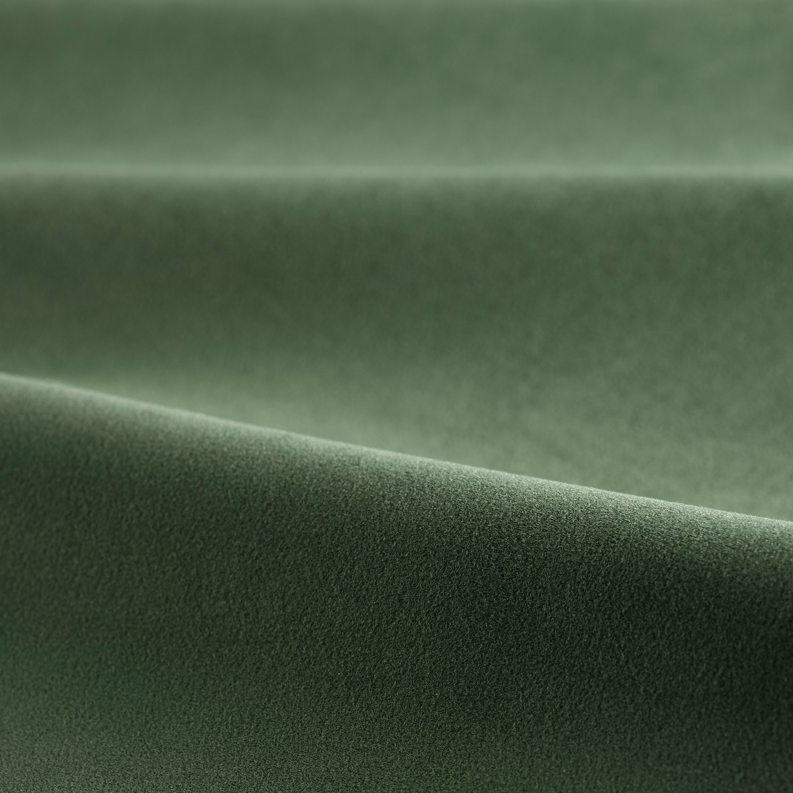 Deep pine green velvet with smooth pile and softly highlighted folded surface
