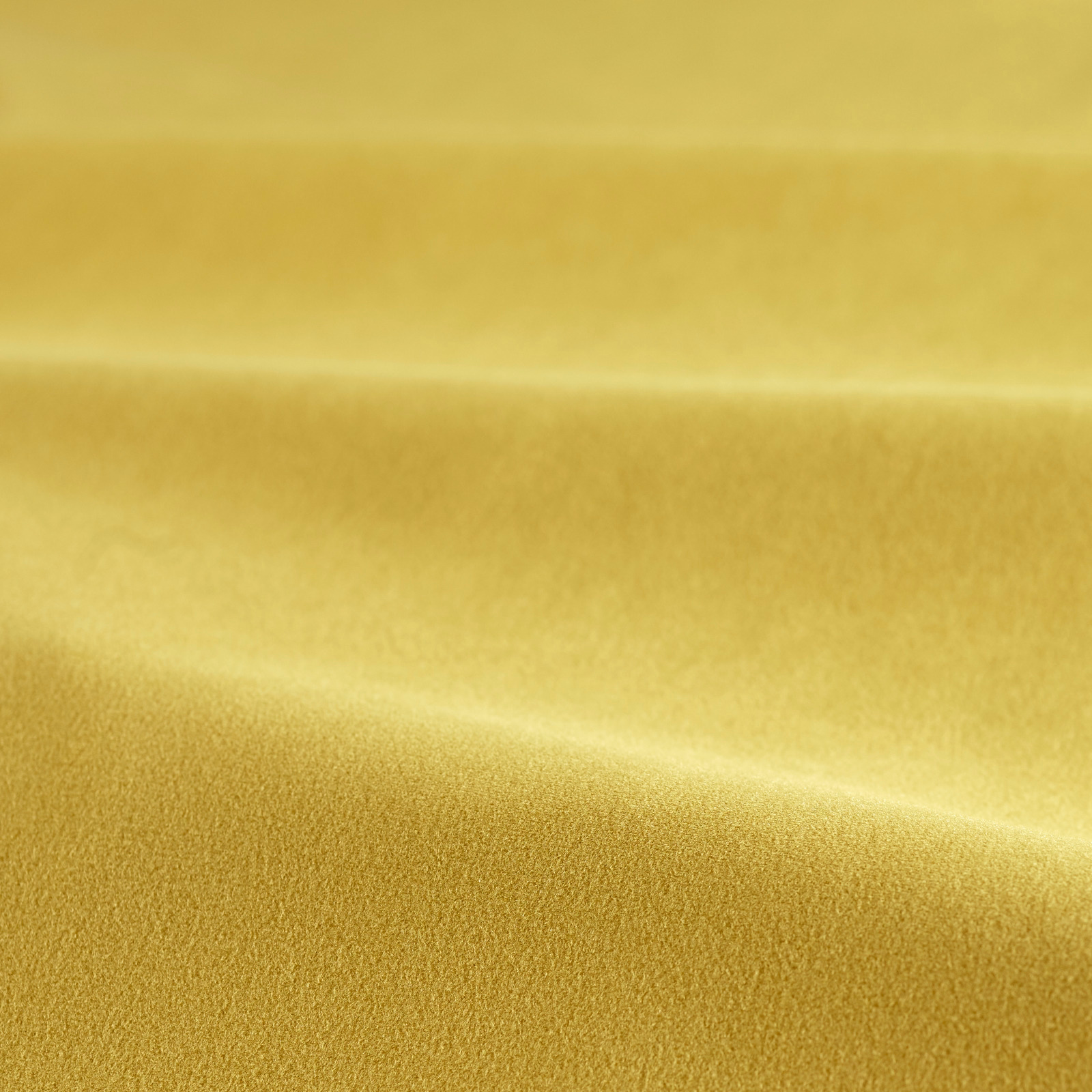 Close-up of warm saffron-gold velvet pile with a softly shifting sheen