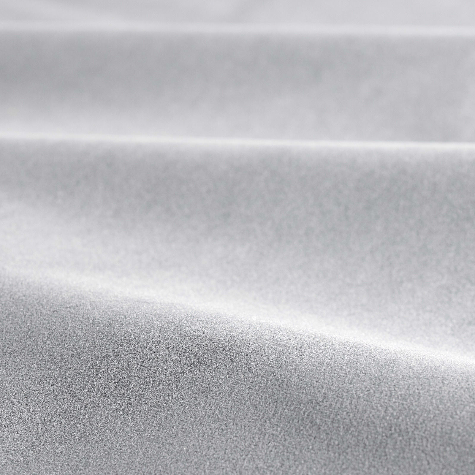 Close-up of cool steel-grey velvet with soft silver highlights across folded pile
