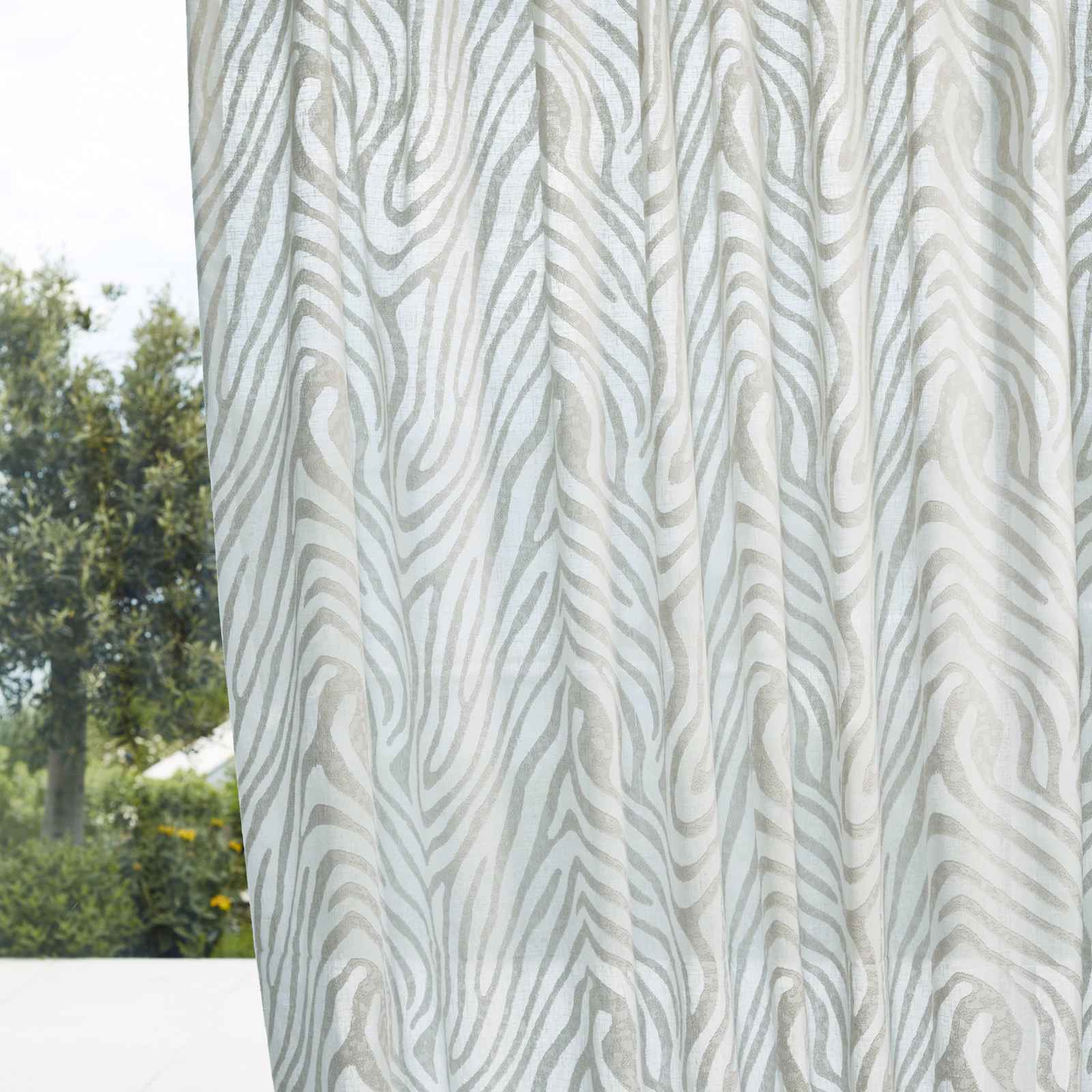 Translucent chalk curtain with pale sage-grey flowing organic stripes in daylight