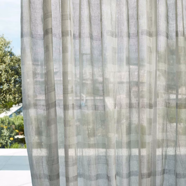 Pale grey-green sheer curtain with translucent woven checks and soft vertical folds
