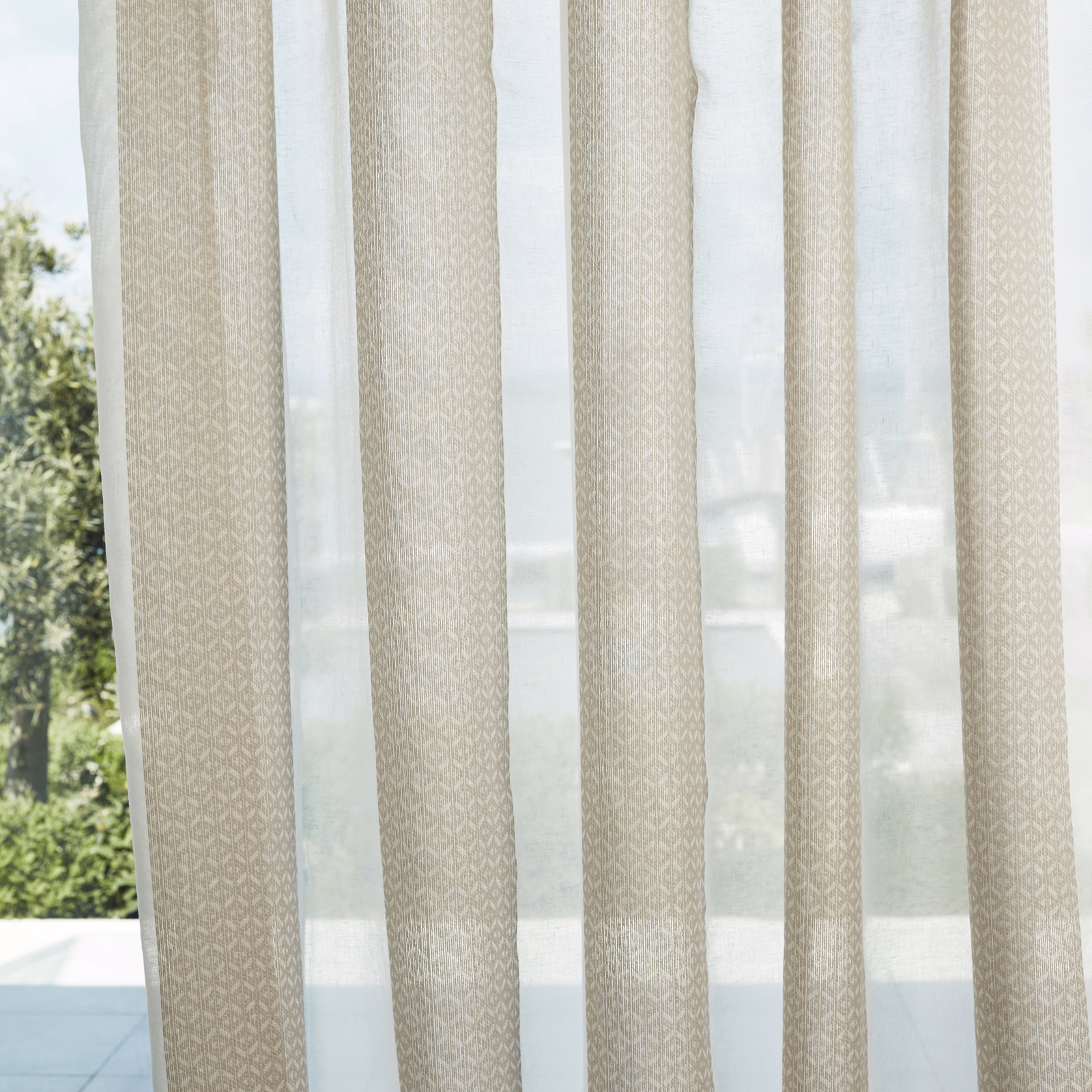 Pale chalk-beige sheer with fine ivory geometric diamonds hanging in vertical curtain panels