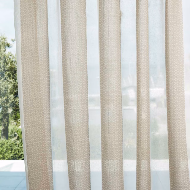 Pale chalk-beige sheer with fine ivory geometric diamonds hanging in vertical curtain panels