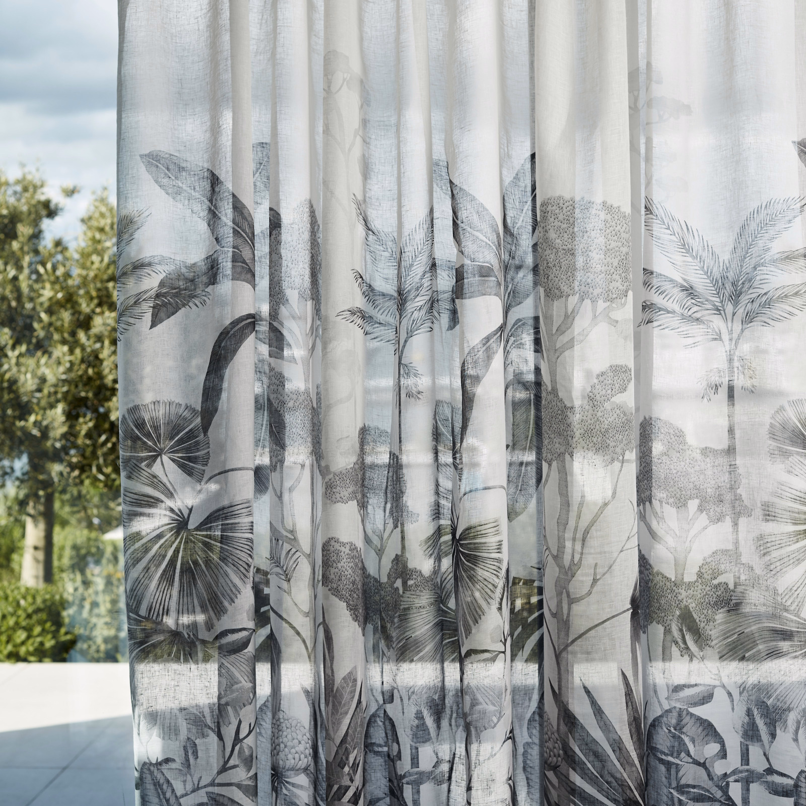 Pale translucent sheer with charcoal palm fronds and layered grey jungle foliage