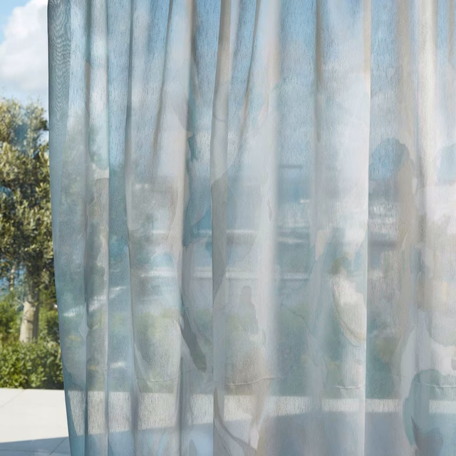 Misty blue-grey sheer curtain with blurred botanical forms and luminous vertical folds