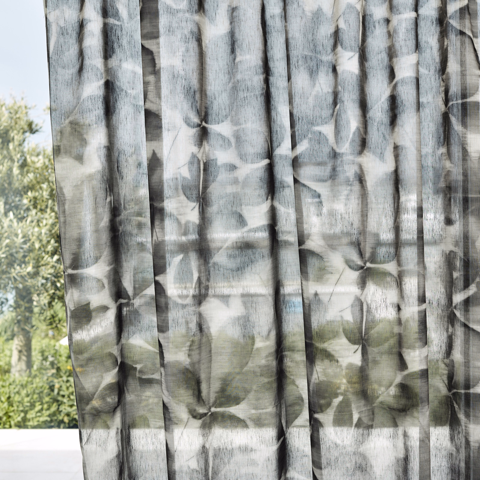 Smoky charcoal sheer curtain with translucent painterly leaves and vertical slub texture