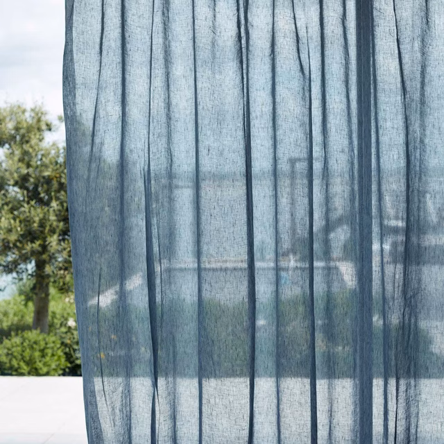 Blue-grey sheer curtain with fine dark vertical lines and visible garden beyond