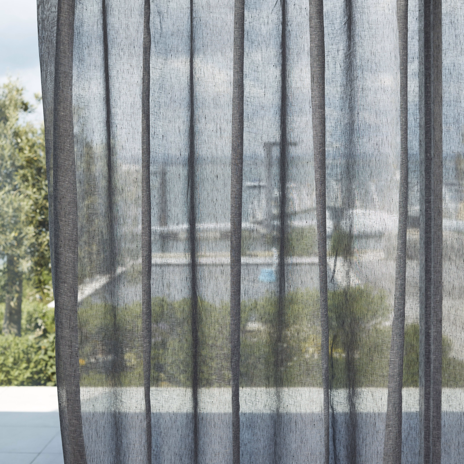 Charcoal-black sheer with darker vertical bands, softly revealing a garden beyond.