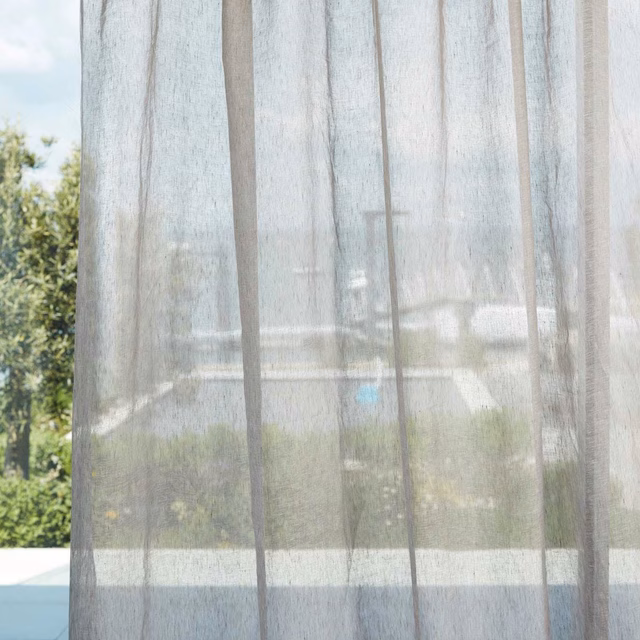 Pale greige sheer with fine vertical weave filtering a sunlit garden view
