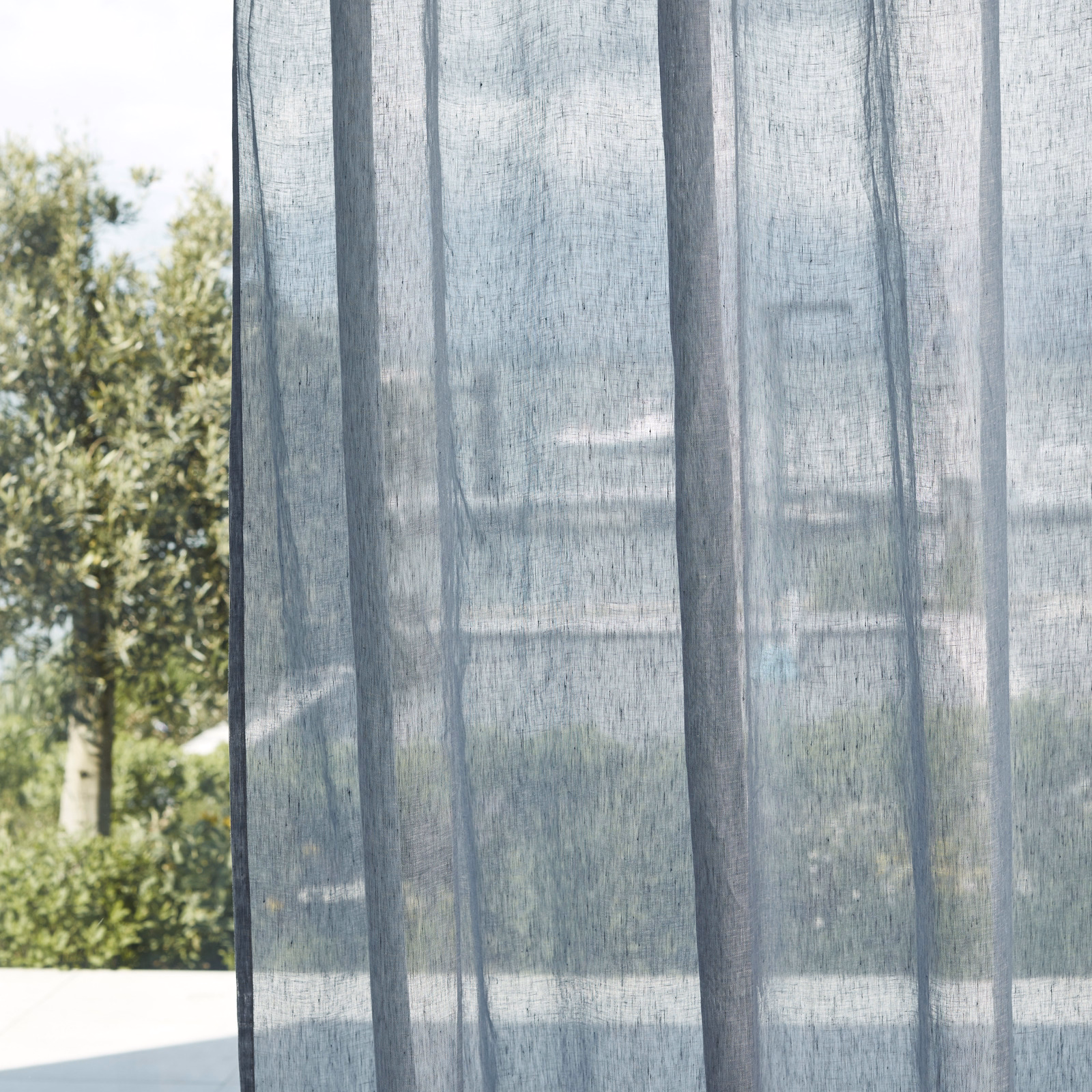 Translucent blue-grey sheer with darker vertical woven bands in daylight