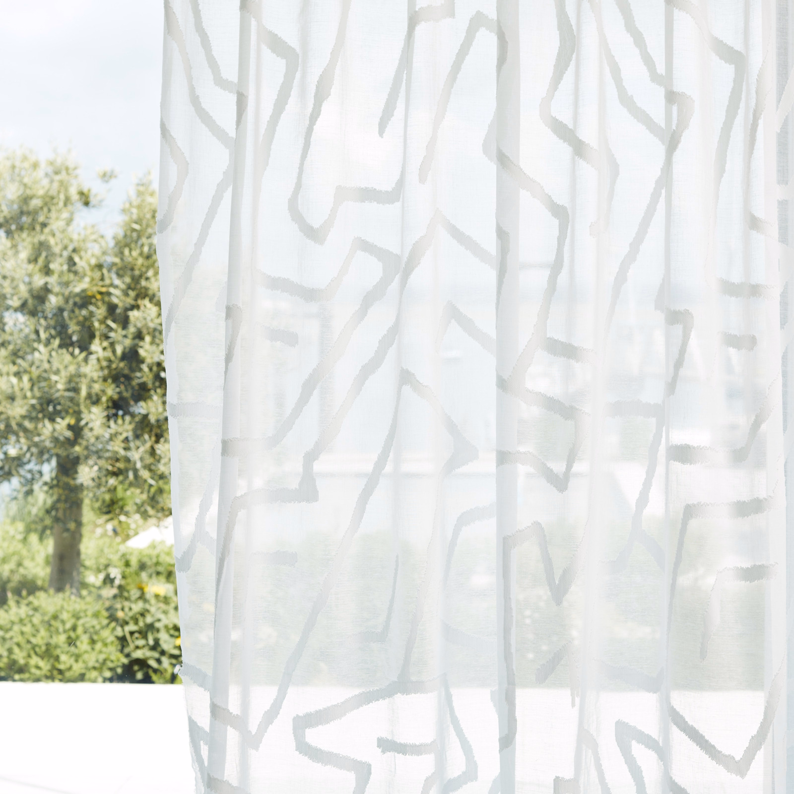 Translucent chalk-white sheer with pale-grey irregular lines glowing in daylight
