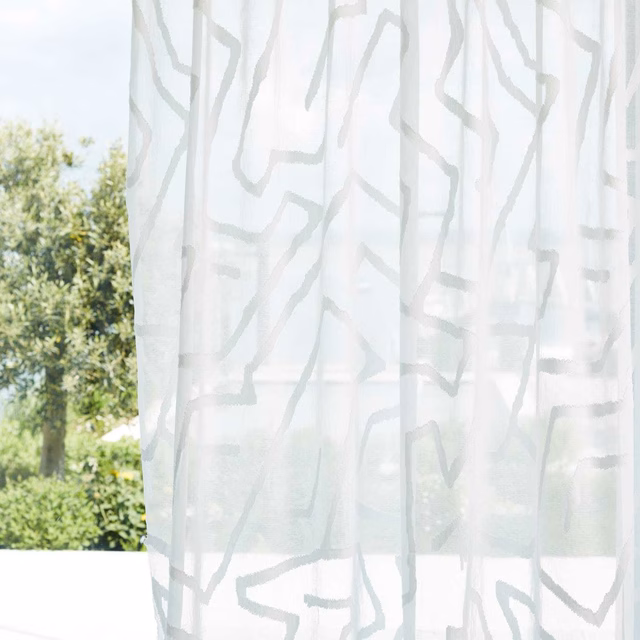 Translucent chalk-white sheer with pale-grey irregular lines glowing in daylight