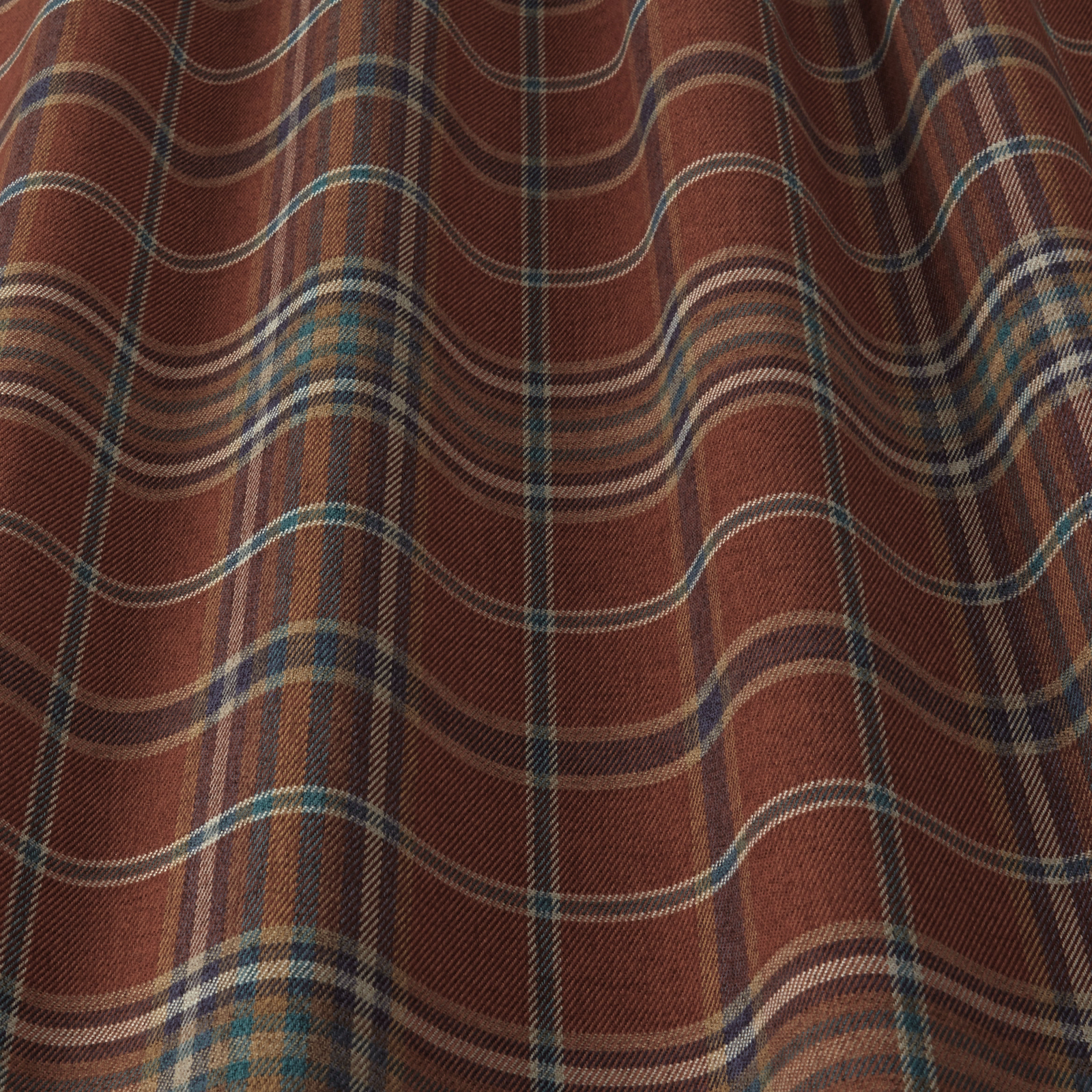 Rust terracotta woven fabric with wavy plaid stripes in teal, cream and brown