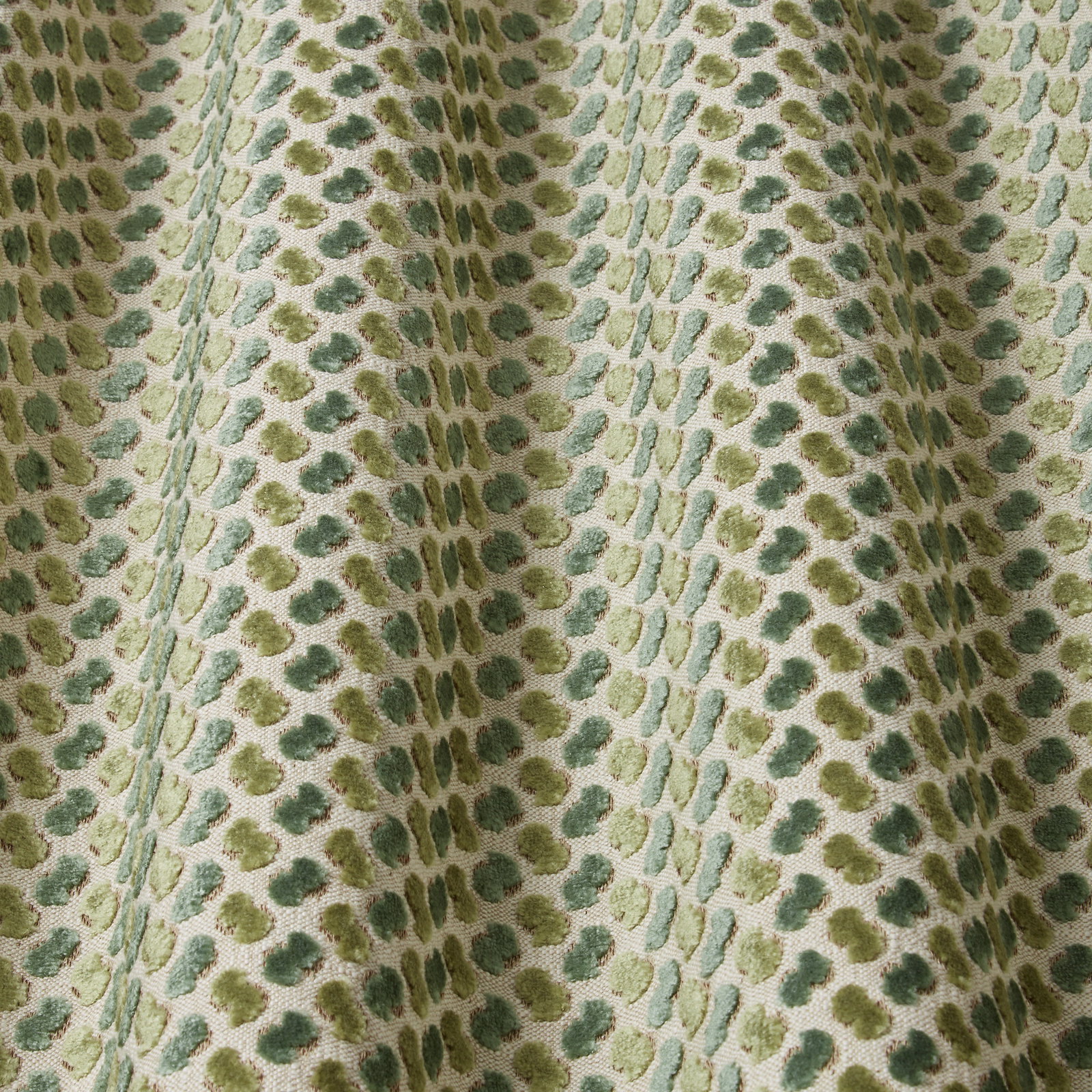 Pale velvet fabric with wavy jade, sage and olive oval motifs