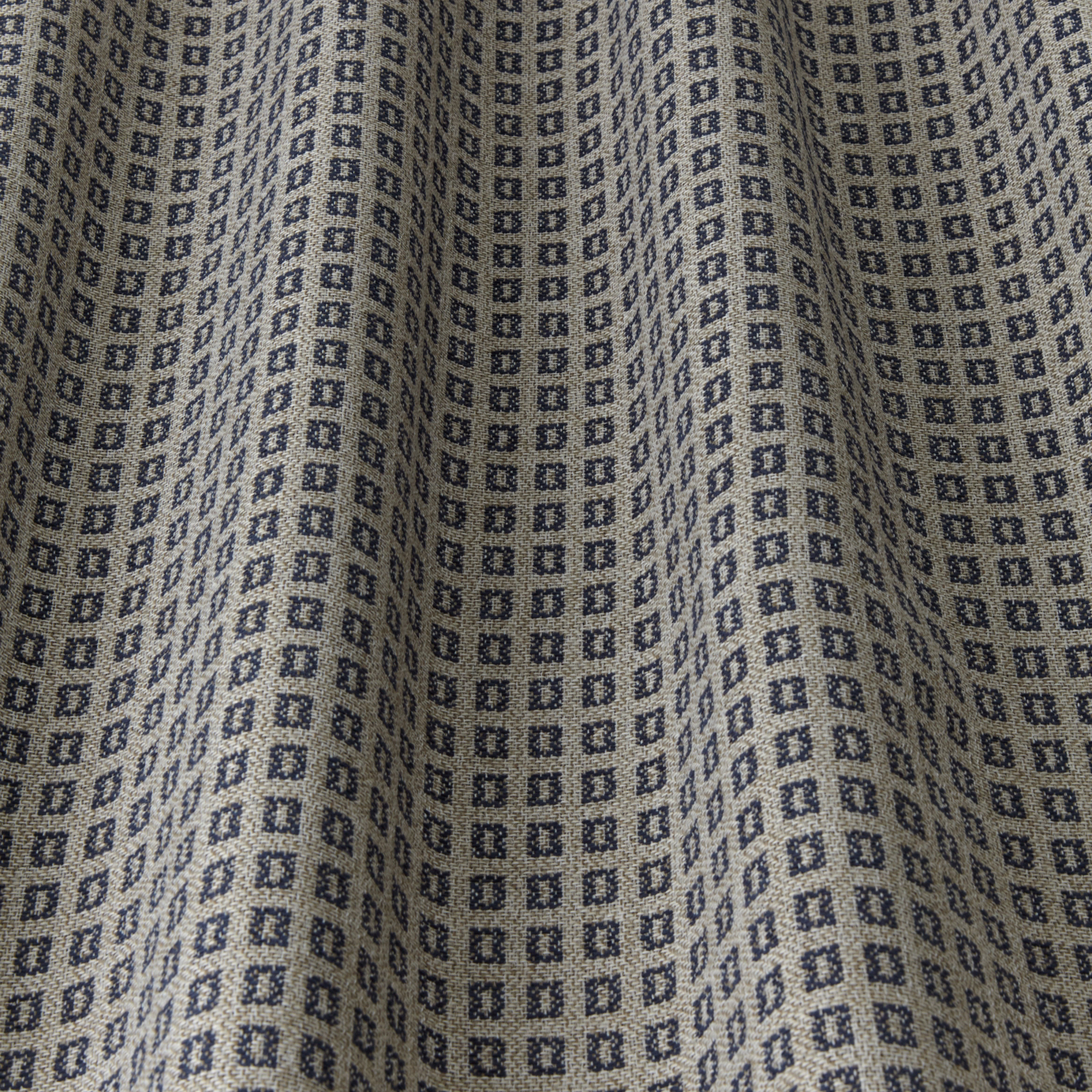 Close-up of navy geometric square motif on a light neutral woven fabric