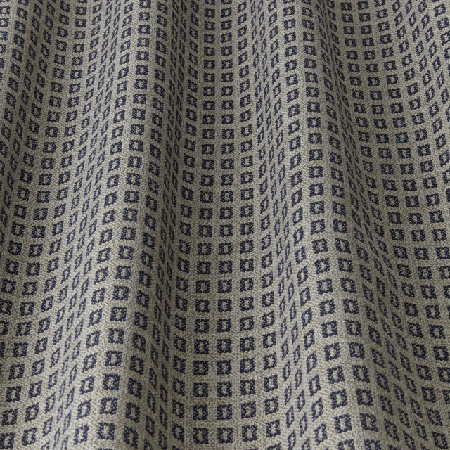 Close-up of navy geometric square motif on a light neutral woven fabric