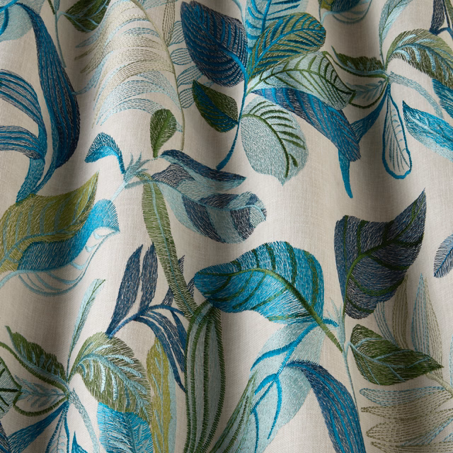 Lagoon teal and navy embroidered leaf pattern on warm ivory fabric