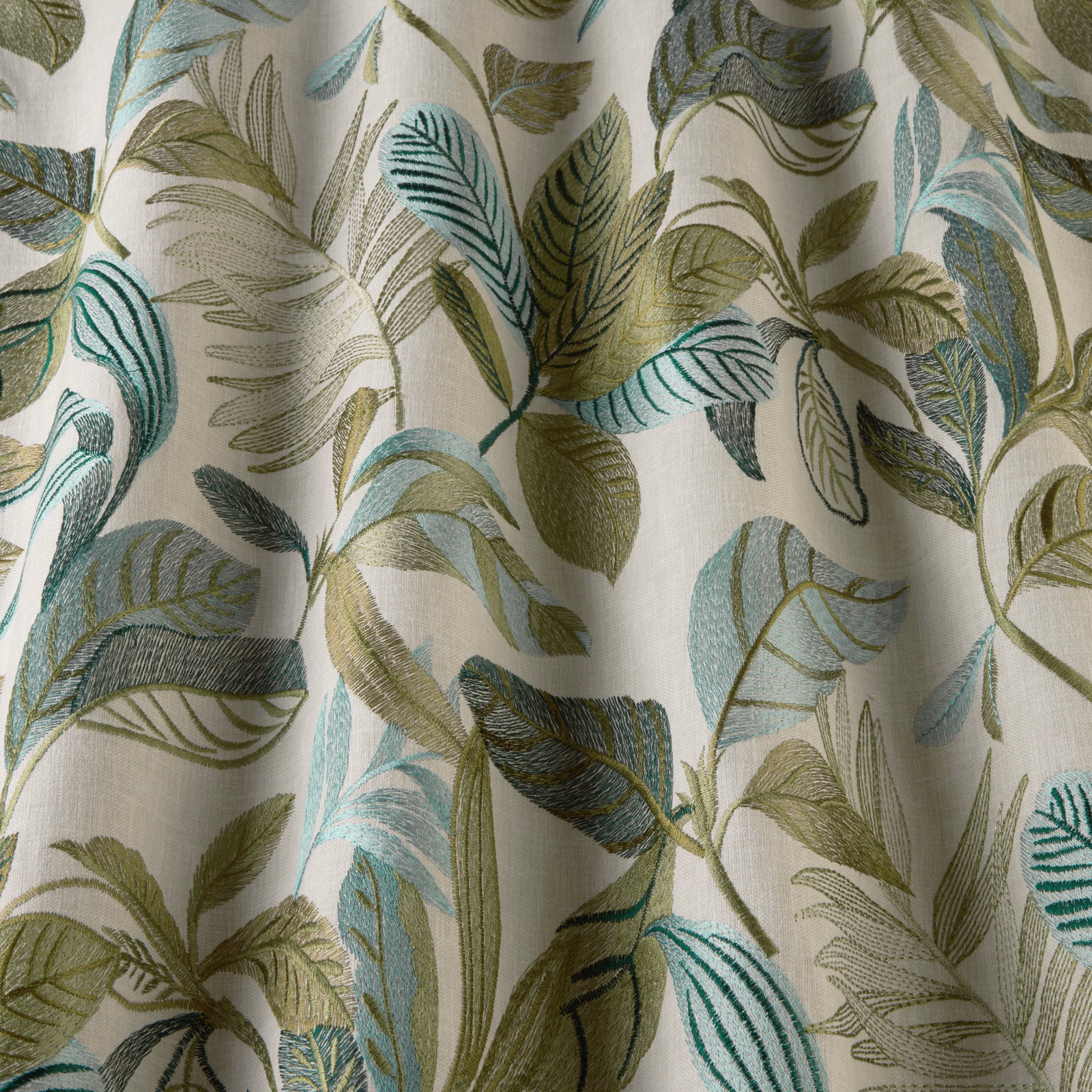 Leafy pistachio, teal and aqua patterned fabric on a soft ivory ground