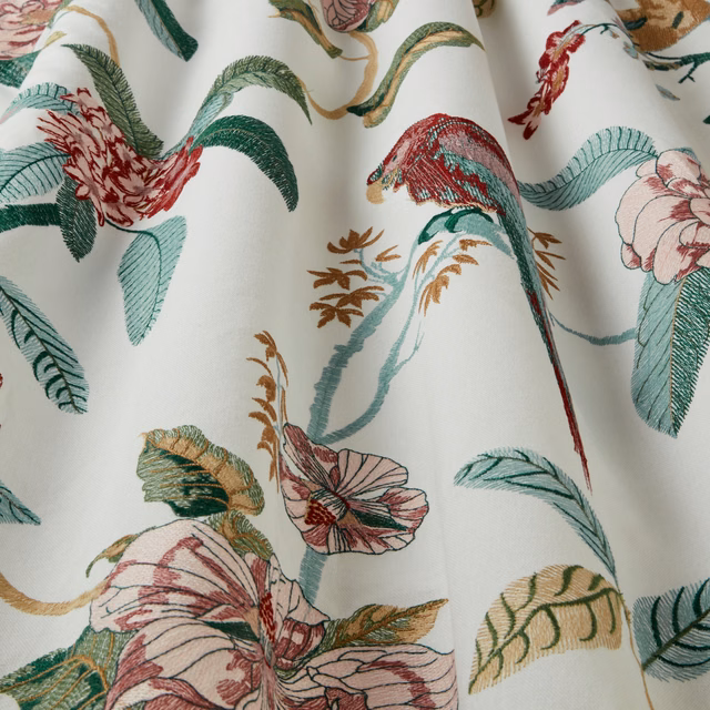 Cream fabric swatch with embroidered birds, damson blooms and teal leaves