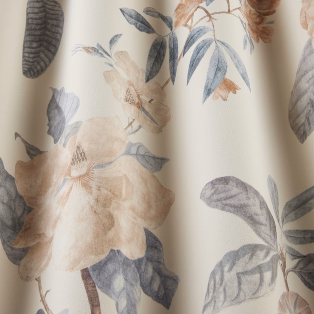 Cream botanical fabric with blush flowers and blue-grey leaves