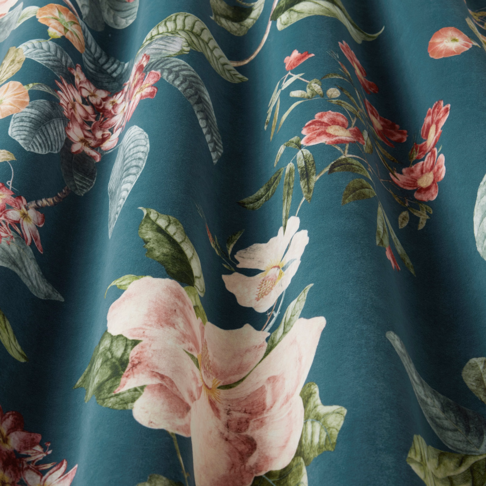 Large botanical floral fabric with pink blooms on a deep teal ground