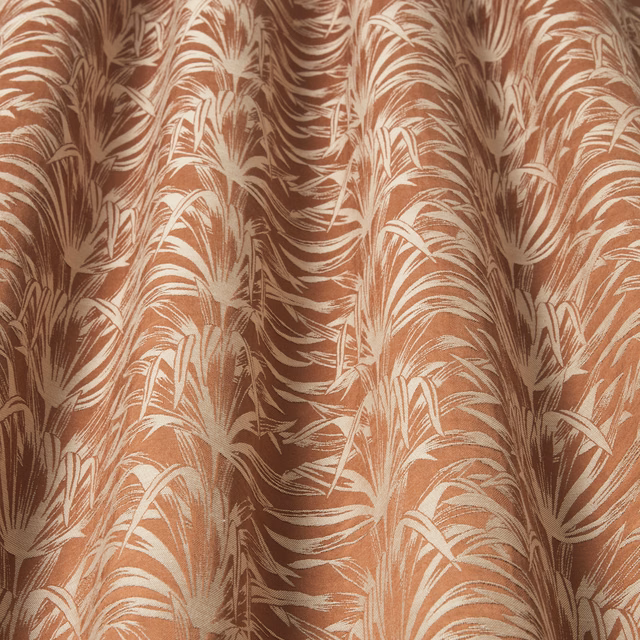 Papaya-orange woven fabric with creamy wavy leaf motif and soft drape