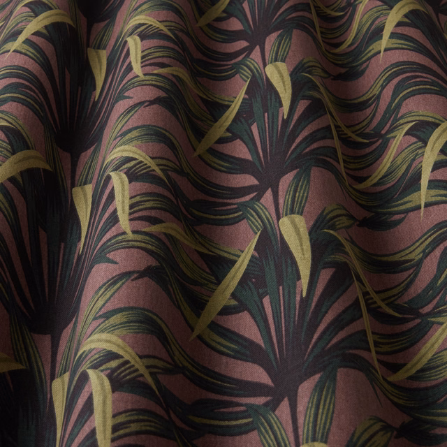 Damson pink botanical fabric with sweeping dark leaves and olive accents