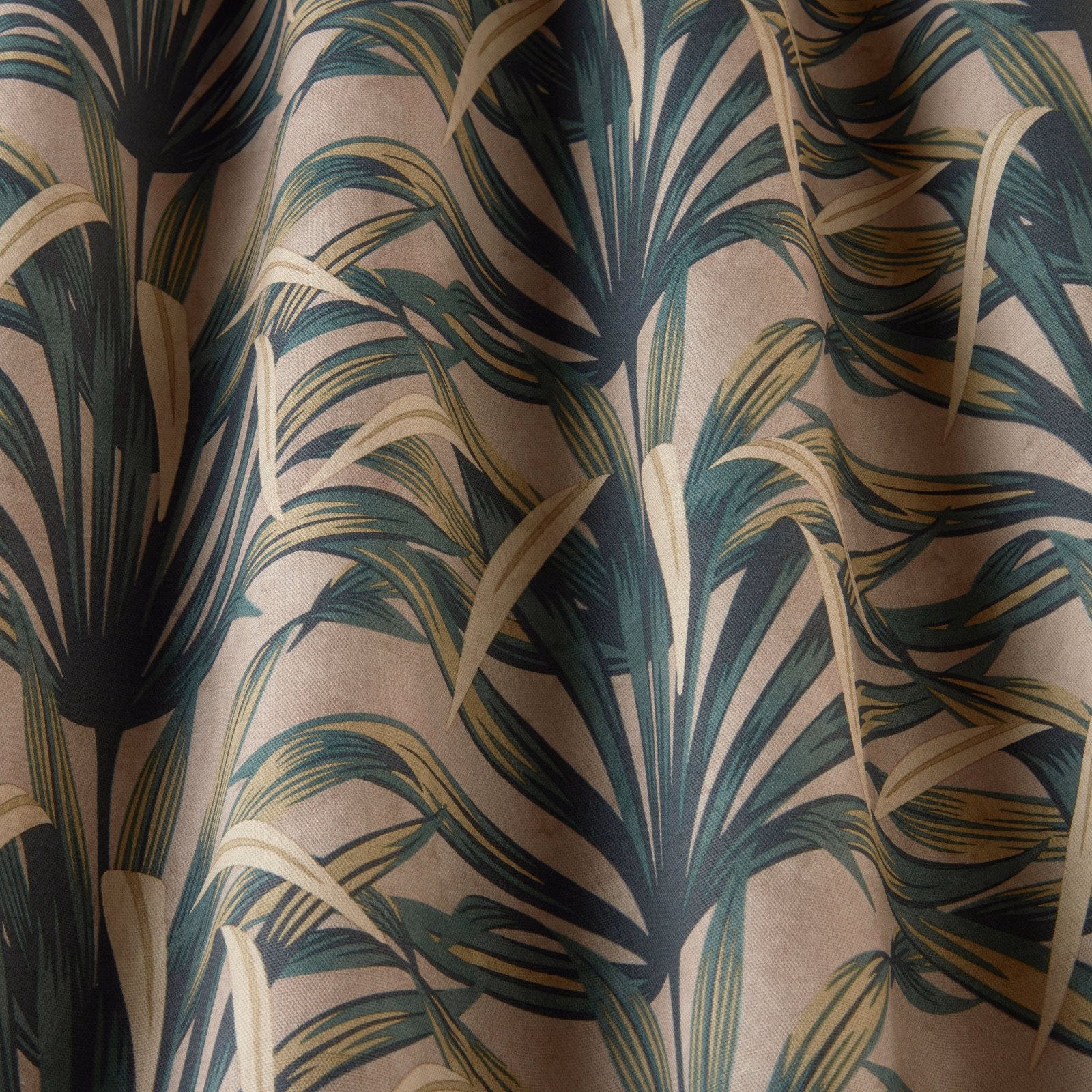 Large-scale tropical leaf print in deep teal, olive and beige on a warm neutral ground