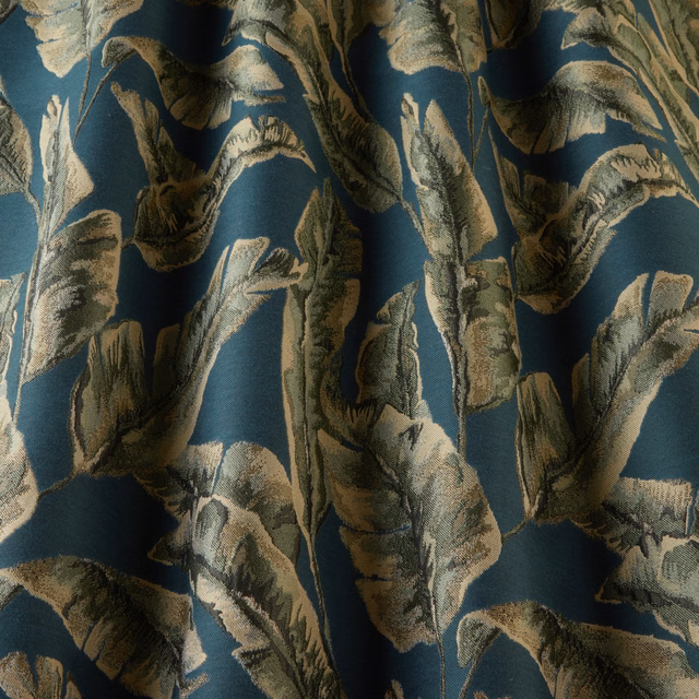 Teal botanical woven fabric with oversized cream and olive leaves in soft folds
