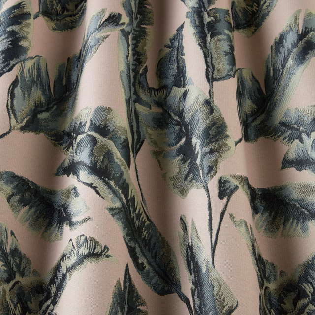 Blush pink fabric with large wavy green and blue-green botanical leaves