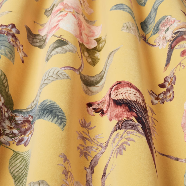 Golden yellow printed fabric with painterly birds and flowing botanical leaves