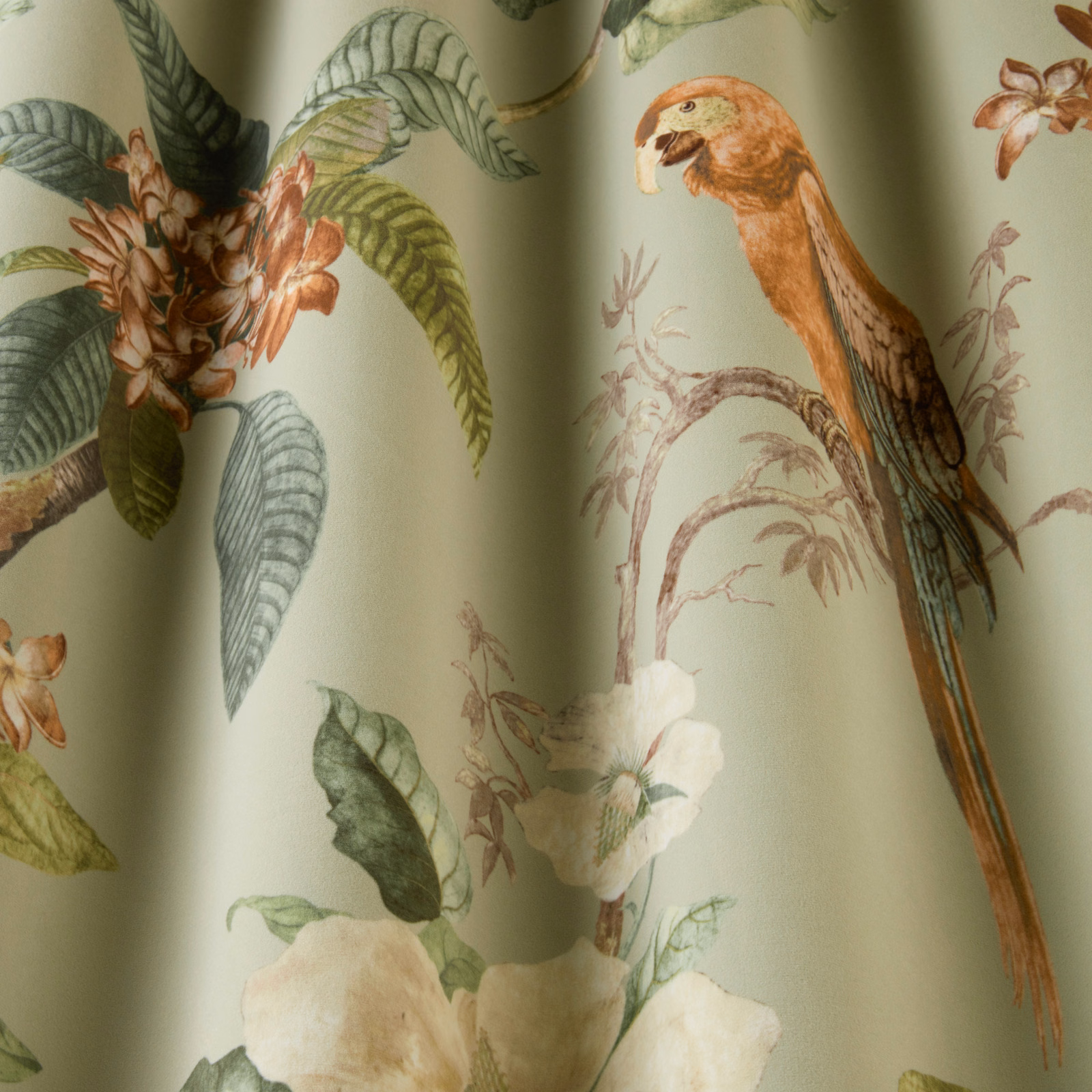 Pistachio green botanical fabric with a printed parrot, leaves and flowers