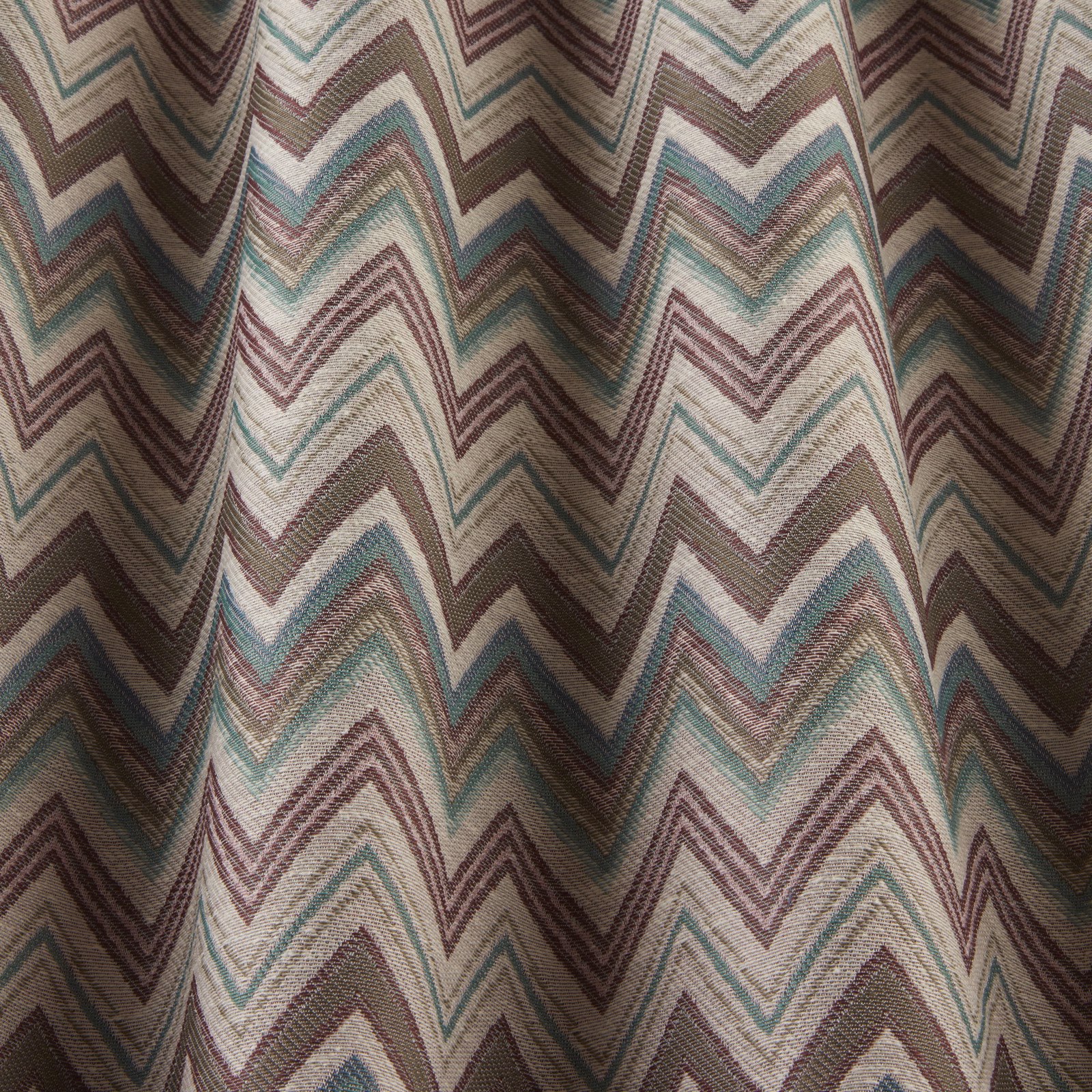 Woven zigzag fabric in damson, teal and sage on a pale ground
