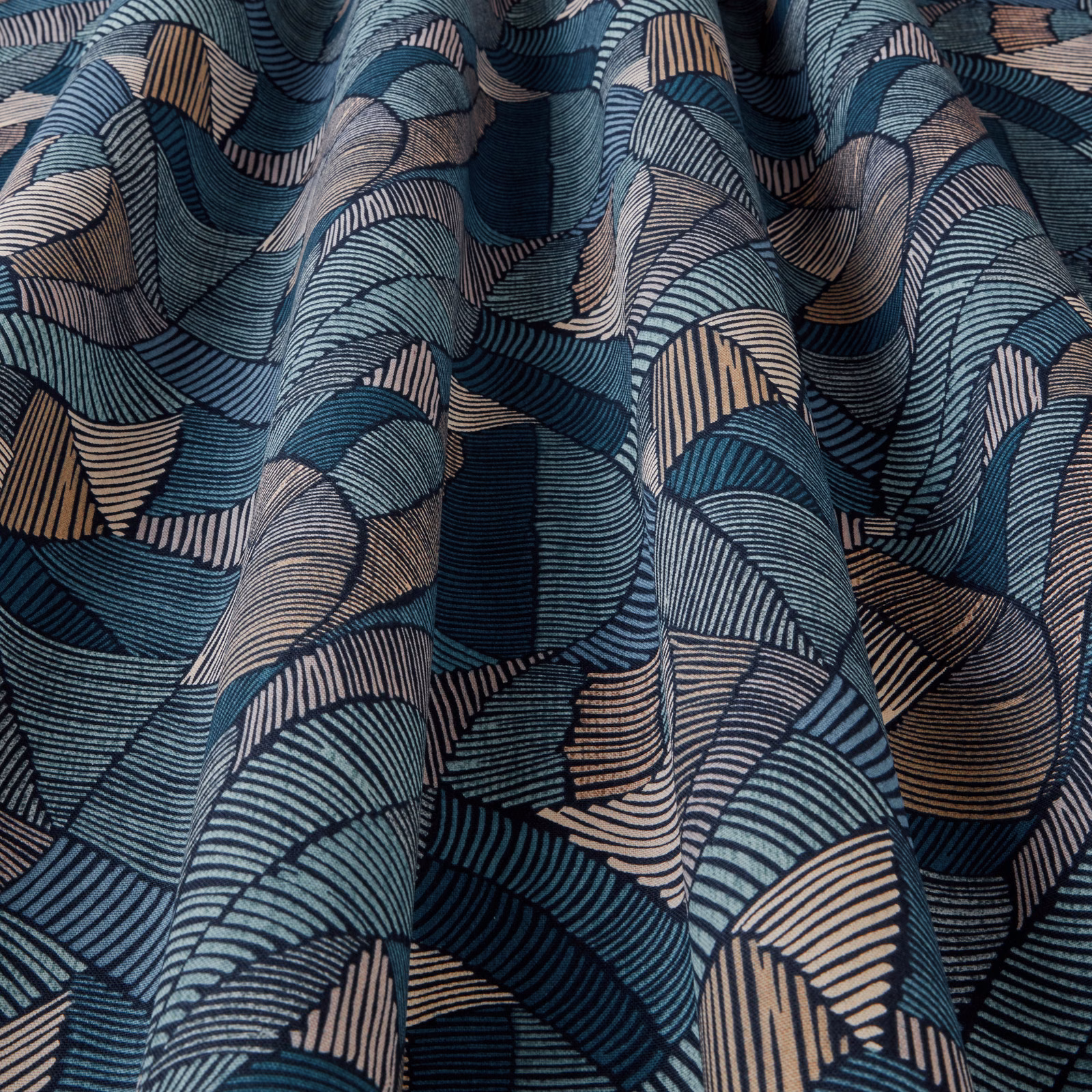 Folded teal, navy and beige geometric wave-pattern fabric with fine striped arcs