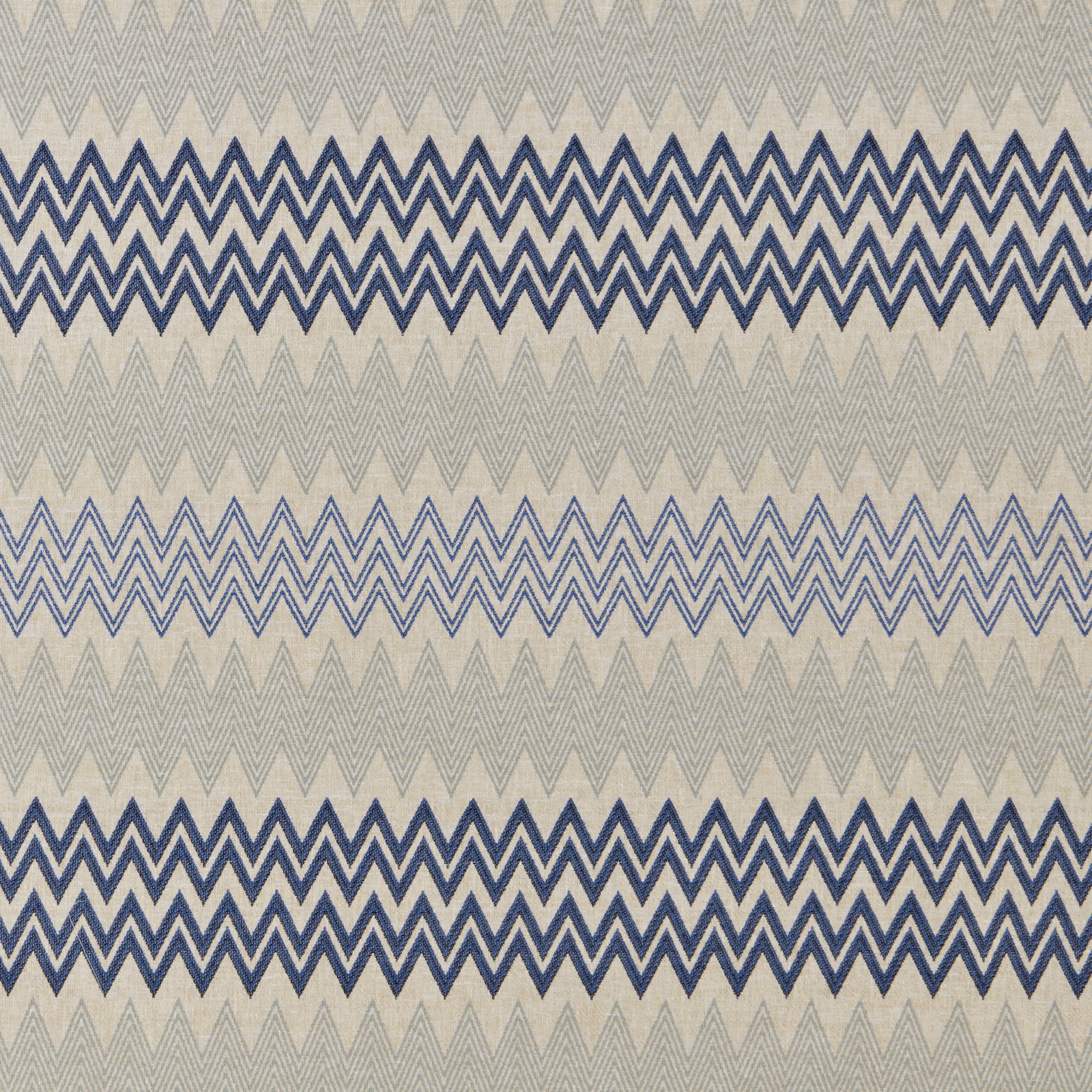 Blue zigzag geometric fabric on a pale stone ground with layered stripes