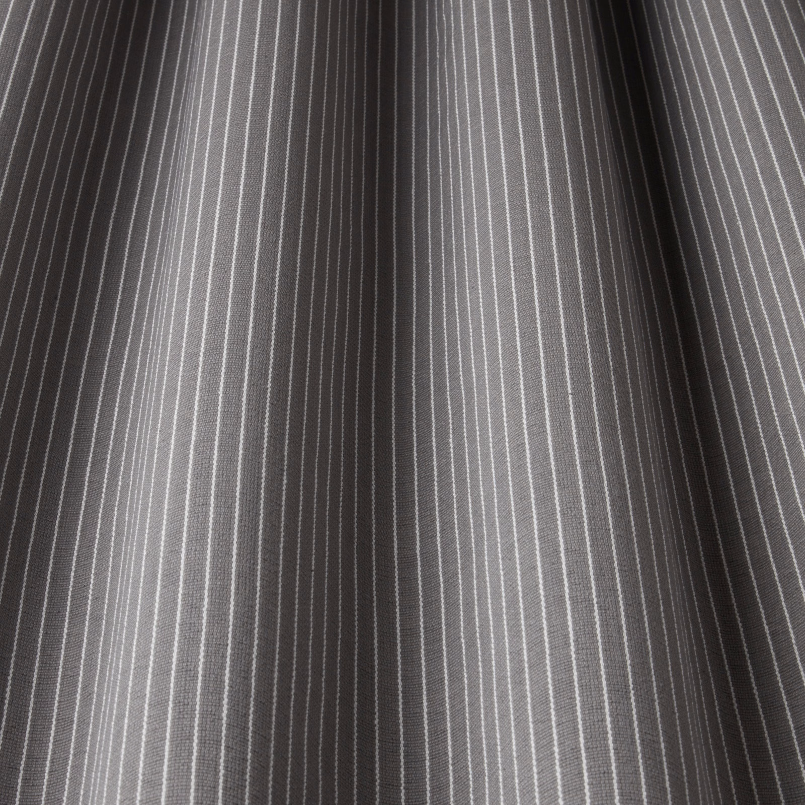 Grey cotton fabric with fine white pinstripes and soft folded drape